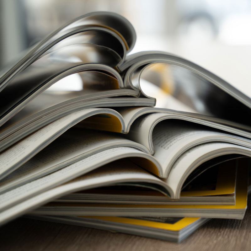 close-up-stacked-open-magazines-showing-curved-pages-blurred-background-publishing-journalism-printed-media-concept-with-room-text